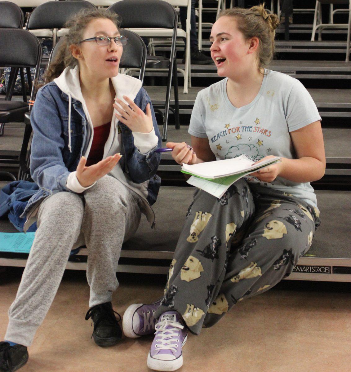 Junior Liza Schoen (left) and senior Olivia Wreden discuss their scripts for the play Drama has taken to competition. 