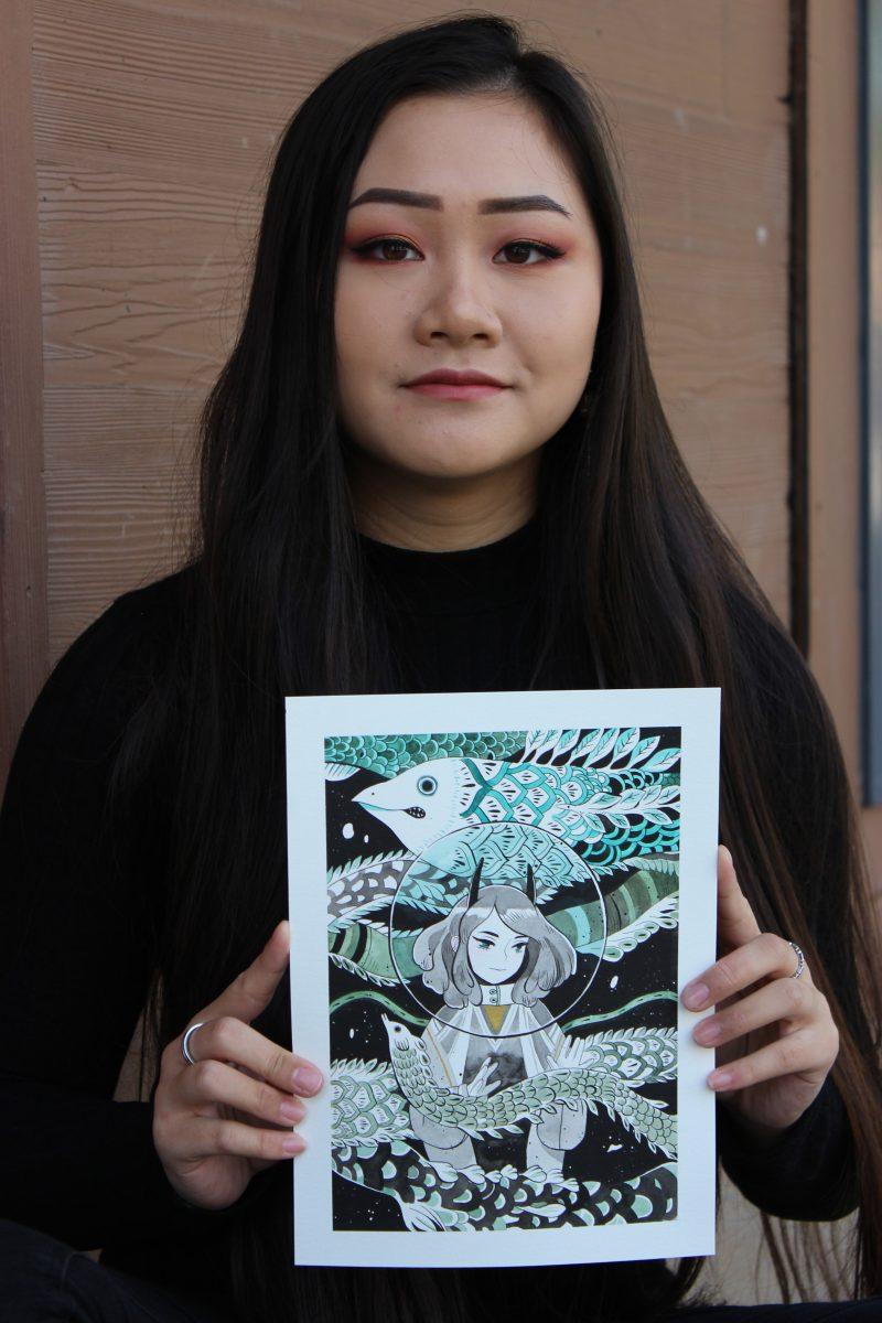 Emmie Lee holds the painting that took her 12 hours to complete featuring a girl underwater. 