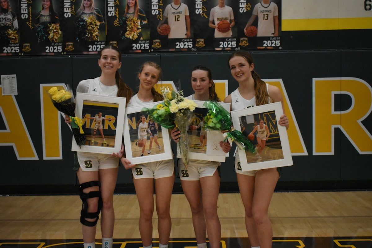 (from left) Seniors Gracie O'Hara, Olivia Maffei, Angela Stickle, and Quincy Dean hold up their portraits awarded to them on senior night. (Courtesy of Quinn Ostroff)