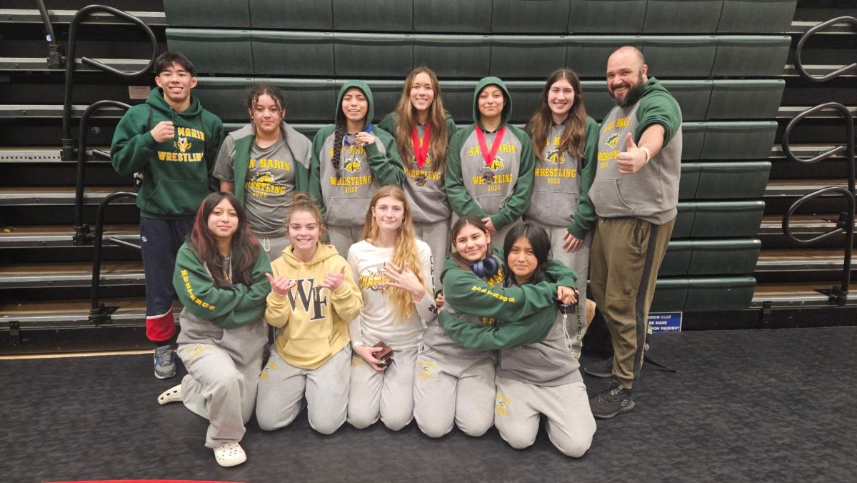 Catania DeKeyrel (bottom center) alongside fellow junior varsity and varsity girls’ wrestlers
posing for a photo after a tournament.